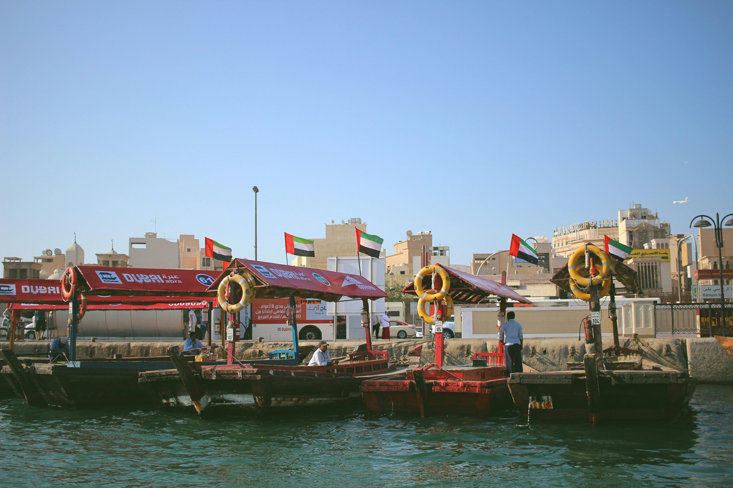 Traditional abra boats crossing Dubai Creek with old town in the background